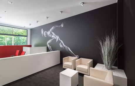 Gestaltung und Einrichtung Aufenthaltsbereich mit weißen Sitzmöbeln und Tisch im Sportshop