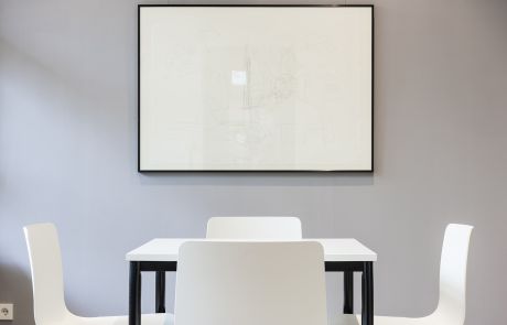Beratungsraum mit weißen Büromöbeln und Wandbild