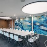 Schulungsraum mit weißen Konferenzmöbeln und runden Deckenleuchten