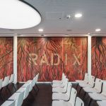 Seminarraum mit Kunst auf den Schiebewänden und weißen Konferenzstühlen