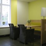 Aufenthaltsbereich mit Holzmöbeln und hellgrünen Wänden