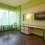 Komfortzimmer mit grünen Vorhängen und grüner Wandfarbe im Krankenhaus