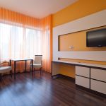 gestaltetes Komfortzimmer mit orangenen Vorhängen und Wänden im Krankenhaus