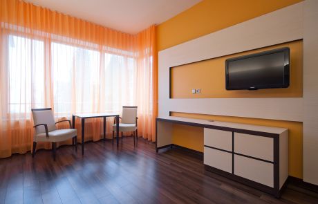 gestaltetes Komfortzimmer mit orangenen Vorhängen und Wänden