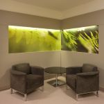 Wartebereich mit Sesseln und hinterleuchteten Wandbildern in Klinik