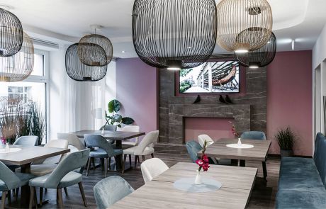 Modernes Restaurant im Hotel mit blauen Sitzbänken und holzfarbenen Tischen