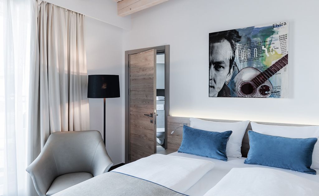 Hotelzimmereinrichtung und Hotelplanung mit einem Doppelbett und einem Sessel