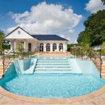 halbrunder Pool mit Treppe im Garten der Villa