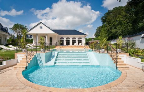 halbrunder Pool mit Treppe im Garten der Villa