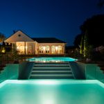 beleuchteter Pool und Poolhaus bei Nacht