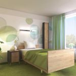 Patientenzimmer mit grünem Teppichboden und grünen Vorhängen