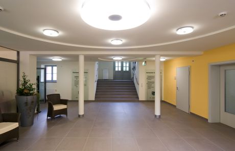 Gestaltung und Einrichtung der Eingangshalle im Rathaus mit runden Deckenleuchten