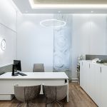 Gestaltung Arbeitsplatz mit weißem Bürotisch und braunen Sesseln