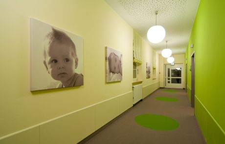 Flurgestaltung mit grüner Wandfarbe und Babybildern
