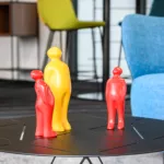 Lounge-Ecke im Büro mit bequemen Sesseln und Tisch mit rotgelben Dekofiguren