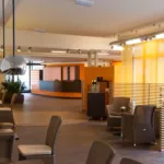 Moderner Foyerbereich mit braunen Korbsesseln im Waldschlösschen Dresden