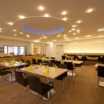 Moderner Restaurantbereich mit stilvoller Beleuchtung und eleganter Tischdekoration